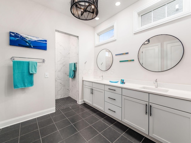 bathroom with a tile shower, vanity, tile patterned floors, and a chandelier