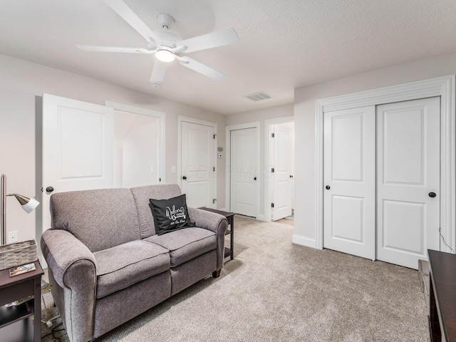 carpeted living room featuring ceiling fan