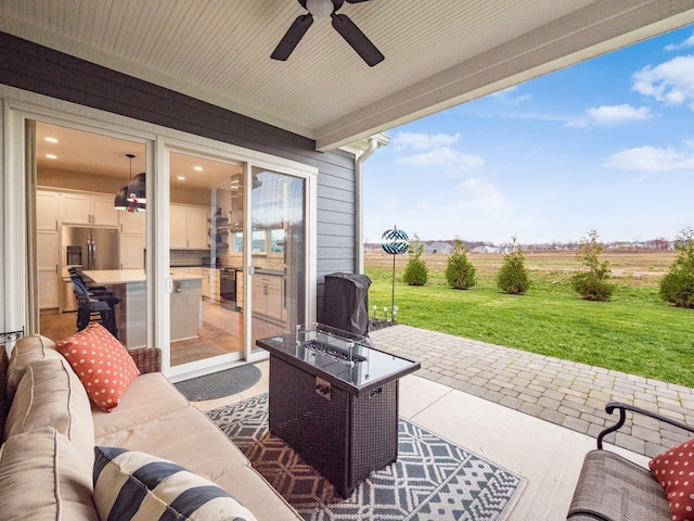 view of patio / terrace with a rural view, an outdoor living space with a fire pit, and ceiling fan