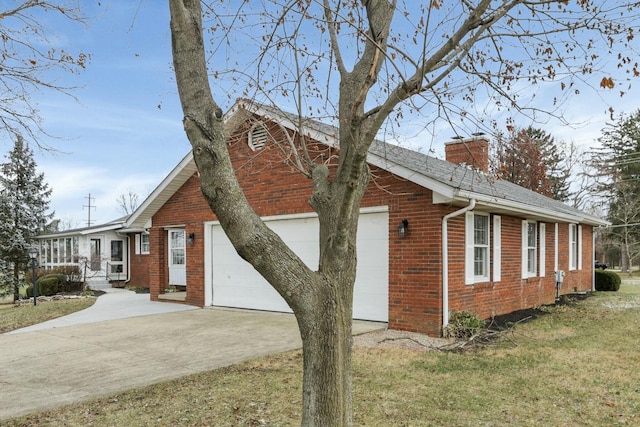 6015 Lithopolis Winchester Rd, Canal Winchester, OH 43110 - view of side of property featuring concrete driveway, a garage, a chimney, brick siding, and a yard