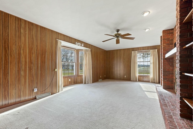 unfurnished living room featuring ceiling fan, carpet floors, and a fireplace