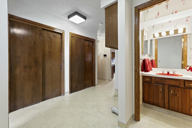 hallway with sink and a textured ceiling