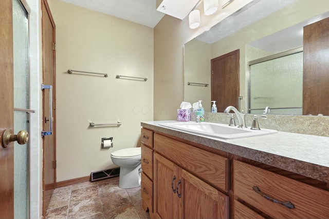 bathroom with vanity, toilet, and a shower with shower door