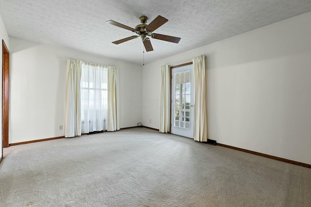 empty room featuring light carpet, a textured ceiling, and ceiling fan