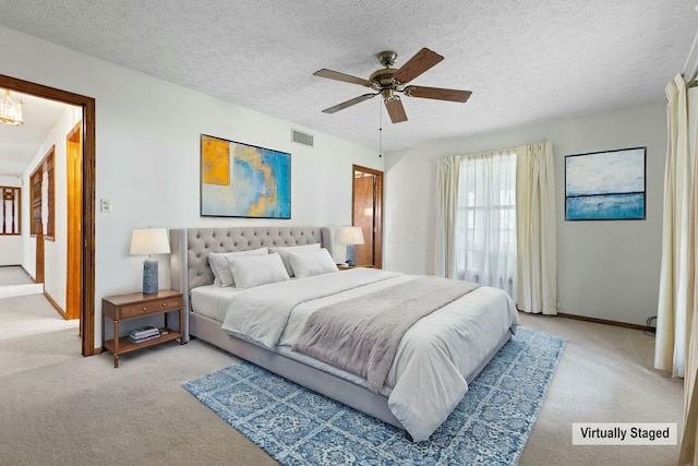 carpeted bedroom with a textured ceiling and ceiling fan