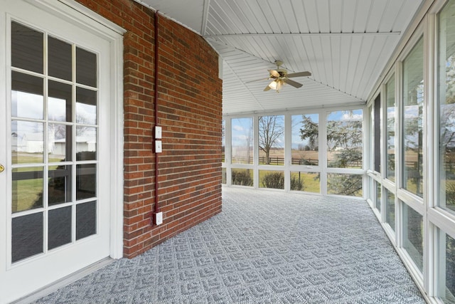 unfurnished sunroom with ceiling fan