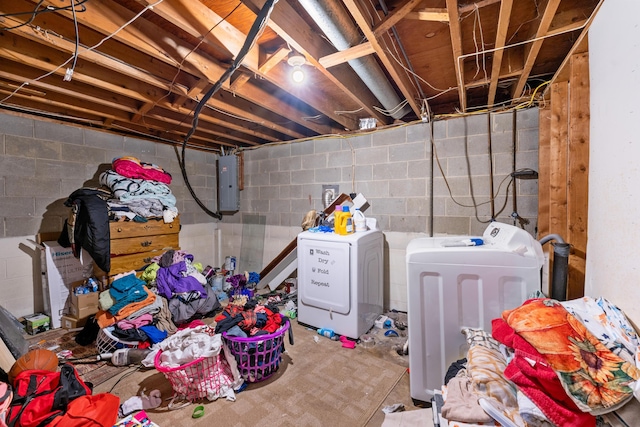 basement featuring electric panel and washing machine and clothes dryer