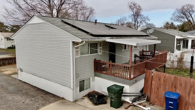 rear view of property with solar panels