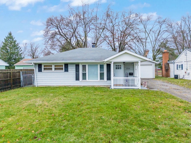 view of front facade with central AC unit, covered porch, a front yard, and a garage