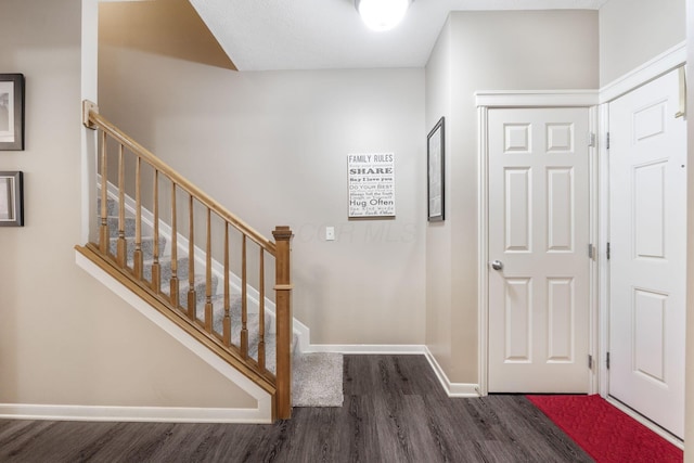 entrance foyer featuring dark wood-type flooring, baseboards, and stairs