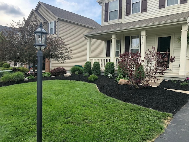 view of front of house with a porch and a lawn