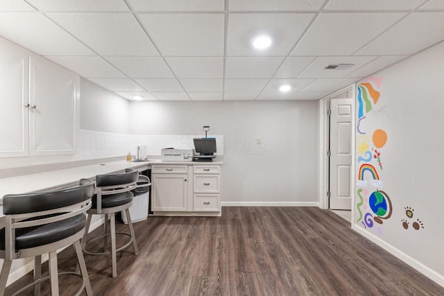 office with dark wood-type flooring, a paneled ceiling, baseboards, and recessed lighting