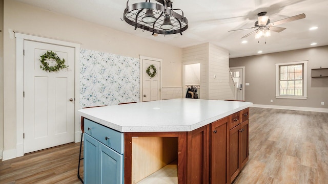 kitchen featuring a kitchen bar, a center island, light hardwood / wood-style flooring, and ceiling fan