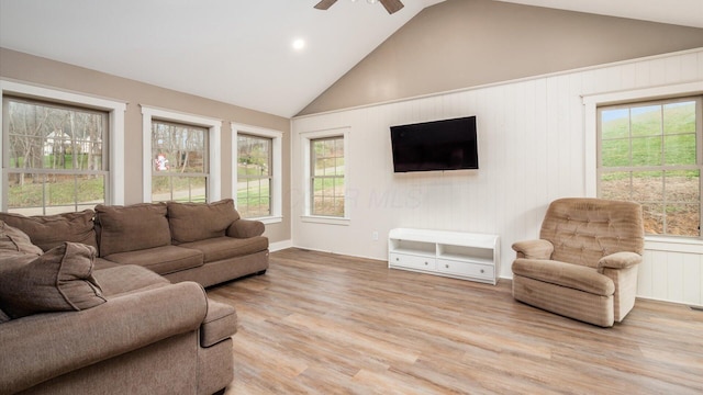 living room featuring ceiling fan, a healthy amount of sunlight, light wood-type flooring, and vaulted ceiling