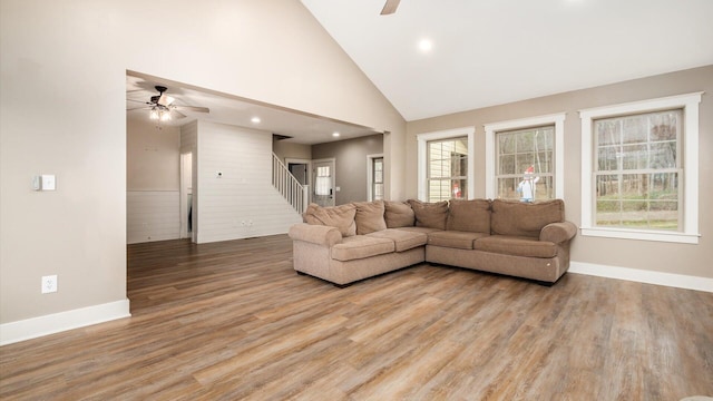 living room featuring hardwood / wood-style floors, ceiling fan, and high vaulted ceiling