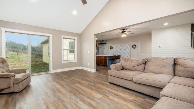 living room featuring ceiling fan, wood-type flooring, and high vaulted ceiling