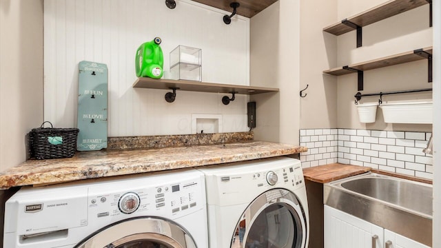 washroom featuring washer and clothes dryer and sink