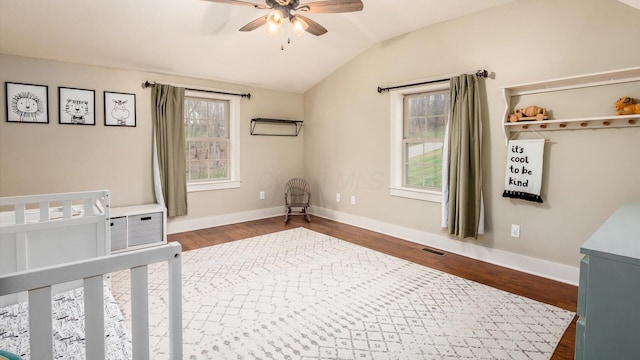 bedroom featuring ceiling fan, dark hardwood / wood-style flooring, and vaulted ceiling