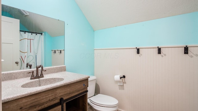 bathroom with a shower with shower curtain, vanity, toilet, and lofted ceiling