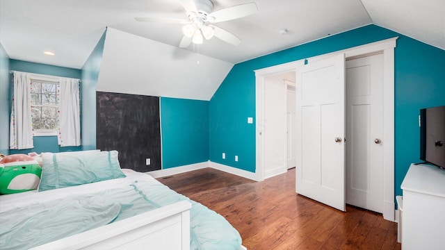 bedroom featuring dark hardwood / wood-style flooring, vaulted ceiling, and ceiling fan