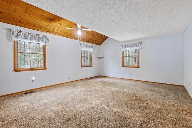 empty room featuring carpet, ceiling fan, a textured ceiling, and vaulted ceiling