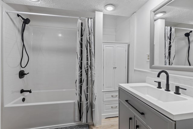 bathroom with vanity, hardwood / wood-style floors, shower / bath combo, and a textured ceiling