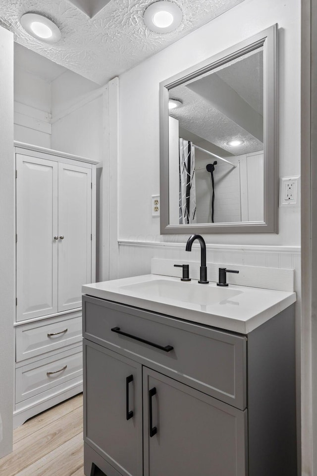 bathroom featuring vanity, a textured ceiling, hardwood / wood-style flooring, and a shower with shower curtain