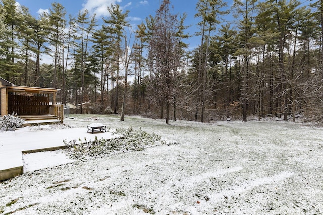 yard layered in snow featuring a deck