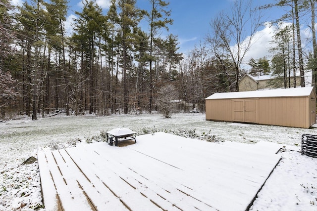 yard layered in snow with an outbuilding