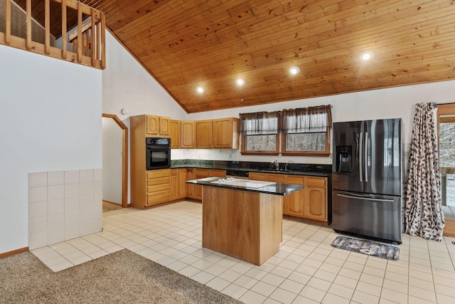 kitchen with plenty of natural light, a center island, oven, and stainless steel refrigerator with ice dispenser