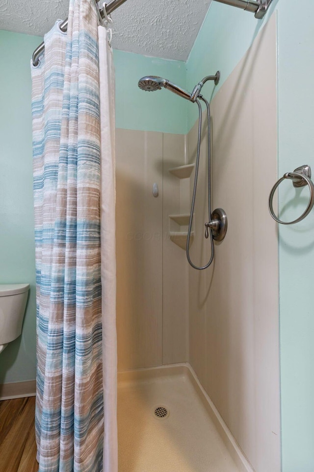 bathroom featuring a shower with curtain, a textured ceiling, and hardwood / wood-style flooring