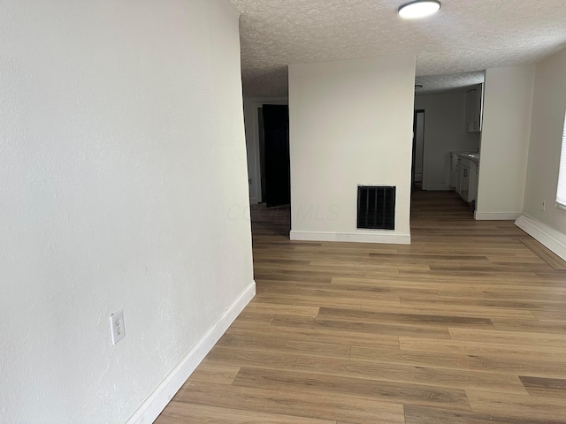 interior space with light wood-type flooring and a textured ceiling