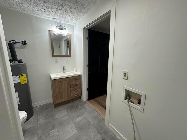 bathroom with vanity, a textured ceiling, electric water heater, and toilet