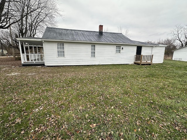 rear view of house with a sunroom and a lawn