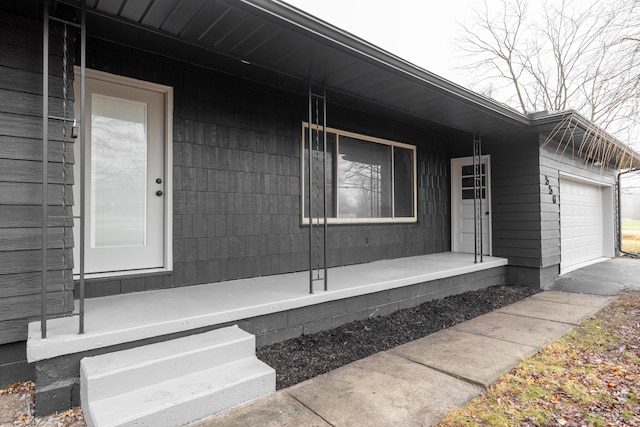 property entrance featuring covered porch and a garage