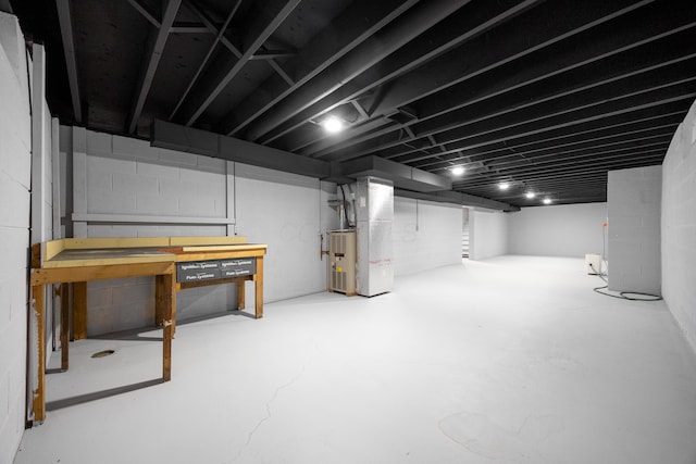 basement featuring a workshop area and heating unit