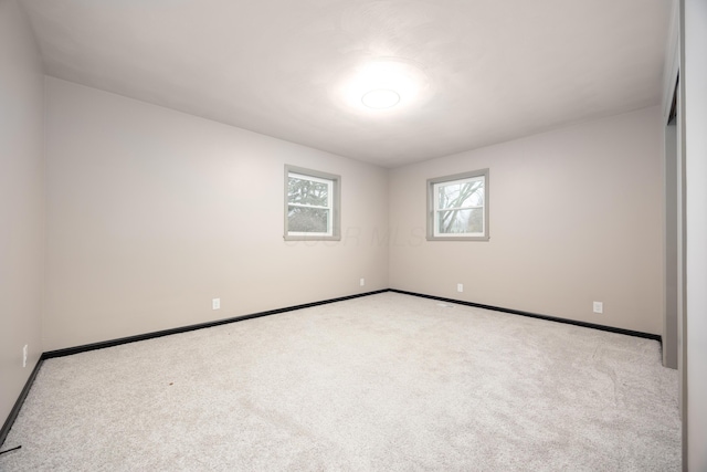 unfurnished room featuring light colored carpet