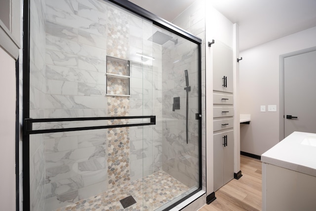 bathroom featuring hardwood / wood-style floors, vanity, and walk in shower