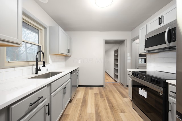 kitchen featuring light hardwood / wood-style flooring, stainless steel appliances, white cabinetry, and sink