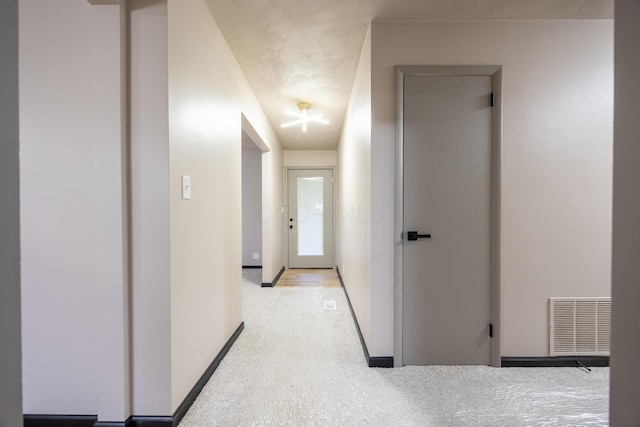 corridor featuring light colored carpet