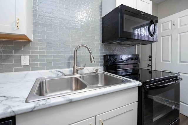 kitchen with black appliances, white cabinets, sink, decorative backsplash, and light stone counters