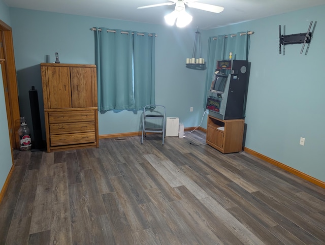 interior space with baseboards, dark wood finished floors, and a ceiling fan