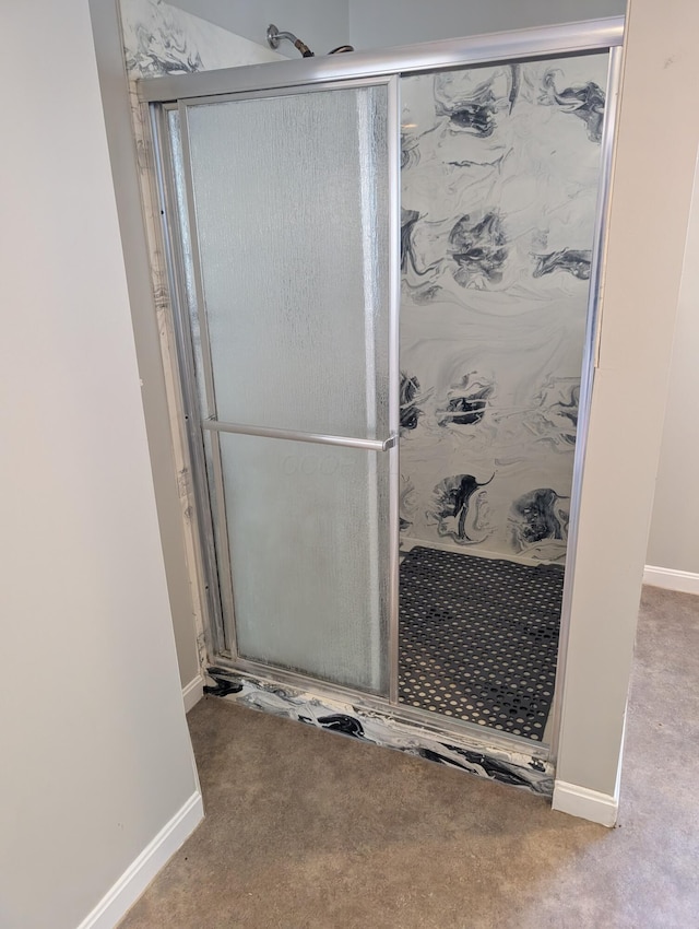 bathroom with carpet floors, a shower stall, and baseboards