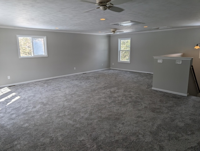 unfurnished room featuring baseboards, ceiling fan, ornamental molding, dark colored carpet, and a textured ceiling