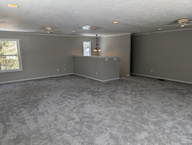 carpeted spare room with a textured ceiling, ornamental molding, a ceiling fan, and baseboards
