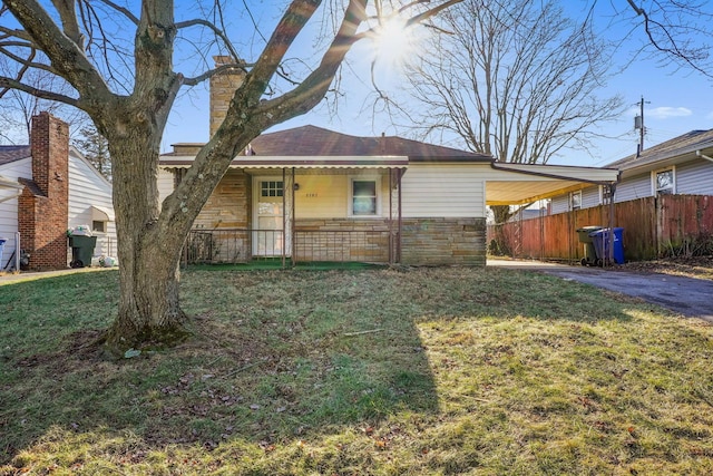 single story home featuring a front lawn and a carport