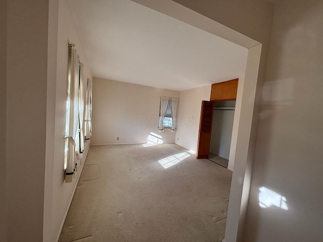 unfurnished bedroom featuring light carpet and a closet