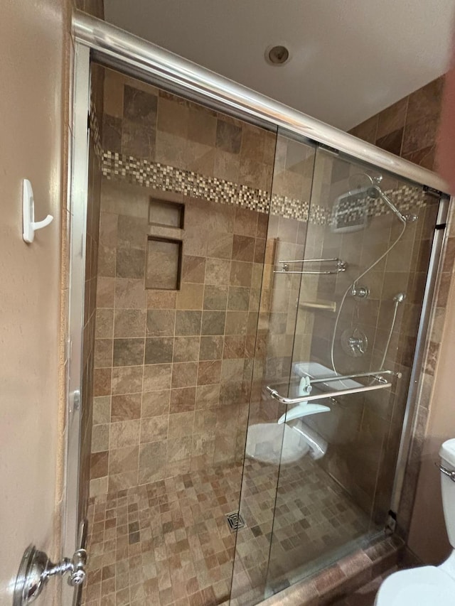 bathroom featuring an enclosed shower and toilet