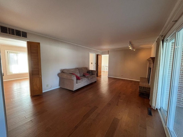 unfurnished living room with a fireplace, wood-type flooring, and ornamental molding