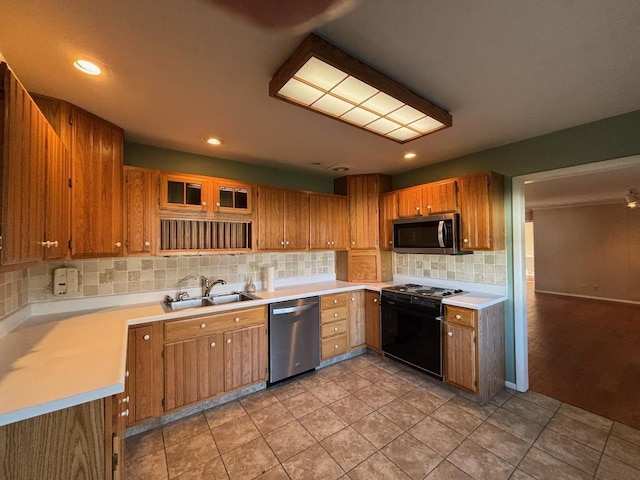 kitchen featuring backsplash, sink, light tile patterned floors, and appliances with stainless steel finishes